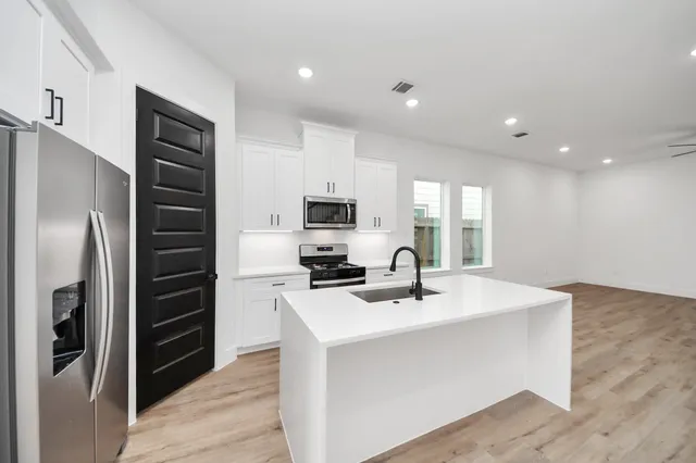 a kitchen with a sink stainless steel appliances and counter space