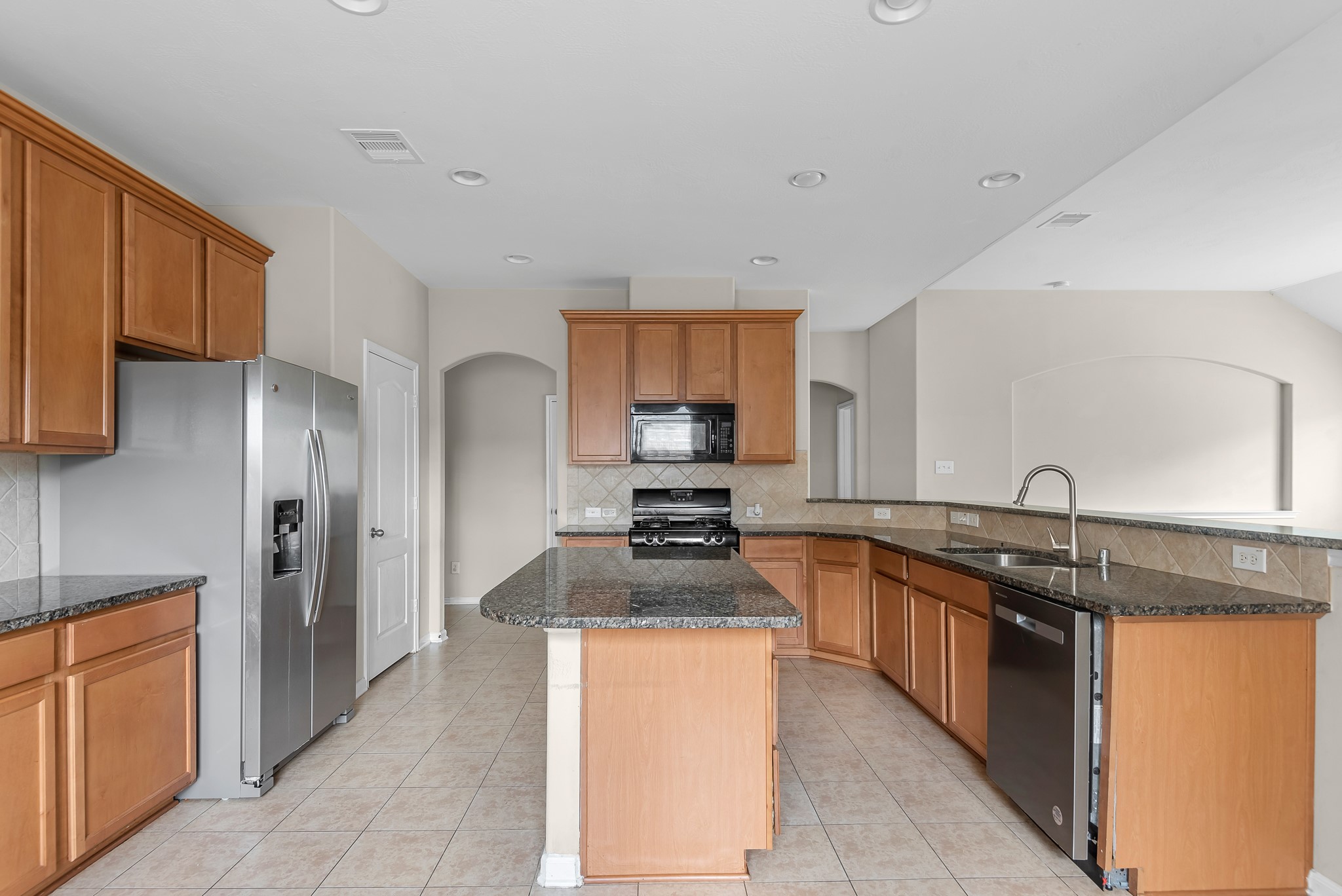 8514 Sweetstone Field Court Cypress, TX 77433 - Photo 3 of 23 a kitchen with stainless steel appliances granite countertop a stove a sink and a refrigerator