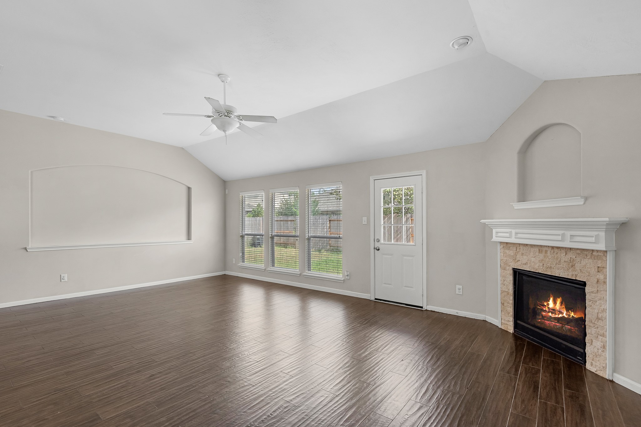 8514 Sweetstone Field Court Cypress, TX 77433 - Photo 10 of 23 a view of an empty room with wooden floor fireplace and a window