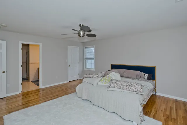 a bedroom with a large bed and wooden floor