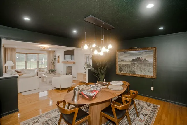 a view of a dining room with furniture a chandelier and wooden floor