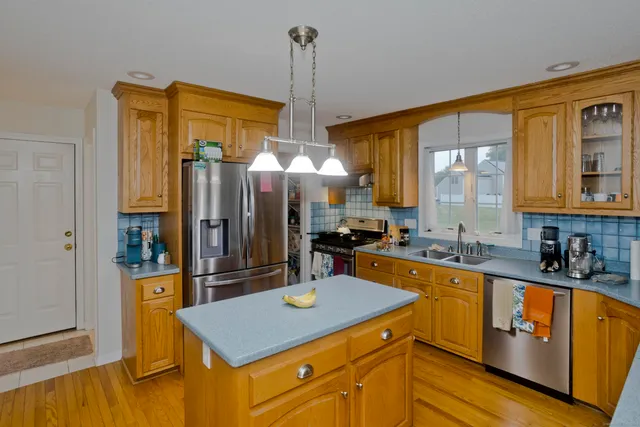 a kitchen with stainless steel appliances granite countertop a sink refrigerator and cabinets