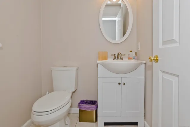 a bathroom with a toilet a sink and mirror
