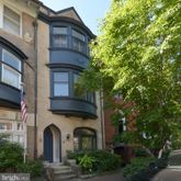 a front view of a house with plants and trees