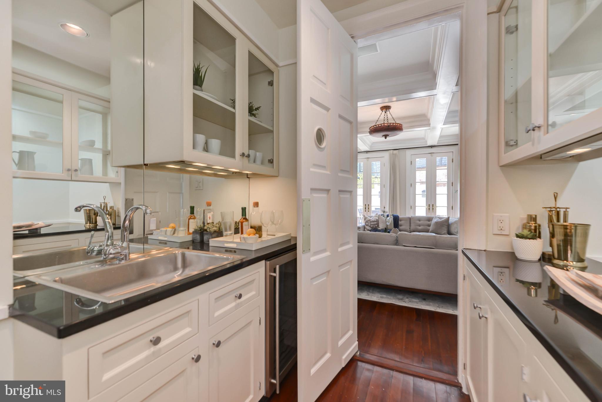 2130 Leroy Place Northwest Washington, DC 20008 - Photo 23 of 98 a kitchen with a sink dishwasher a stove and white cabinets with wooden floor