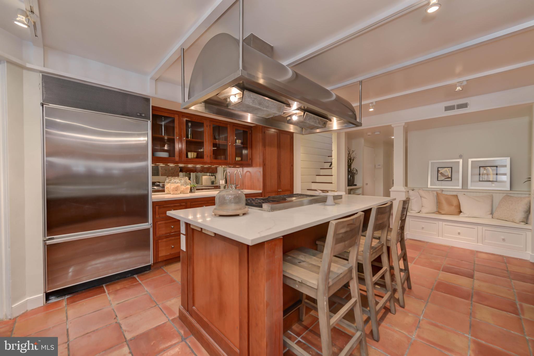 2130 Leroy Place Northwest Washington, DC 20008 - Photo 29 of 98 a kitchen with stainless steel appliances kitchen island granite countertop a table chairs and a refrigerator