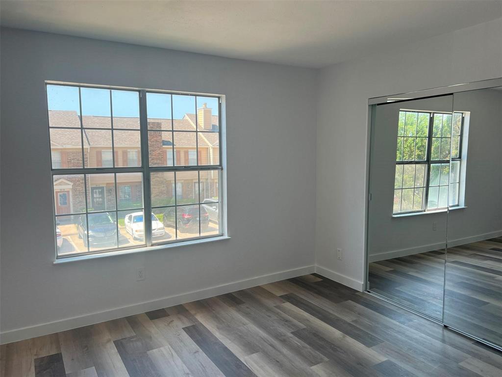 2400 Jupiter Road, Unit 6 Plano, TX 75074 - Photo 4 of 8 a view of an empty room with wooden floor and a window