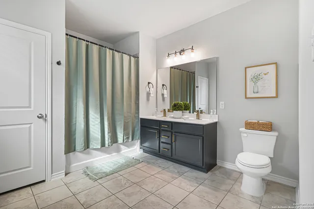 a spacious bathroom with a toilet a sink and a mirror