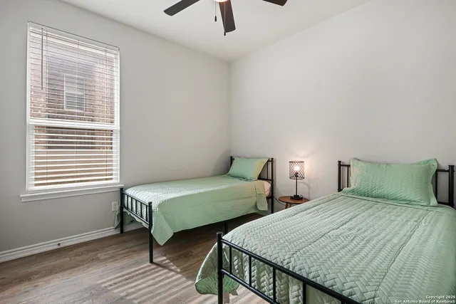 a bedroom with two beds a chandelier and a window
