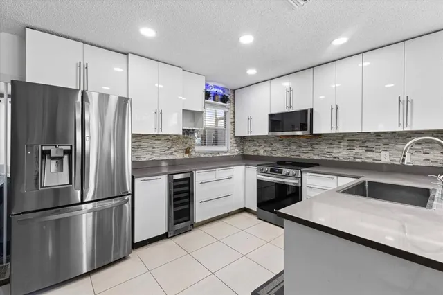 a kitchen with stainless steel appliances a refrigerator sink and microwave