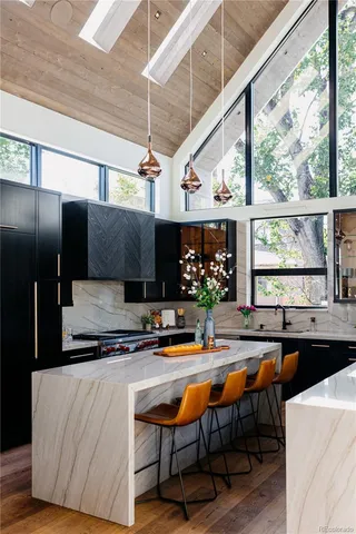 a kitchen with stainless steel appliances granite countertop a sink a stove and a refrigerator