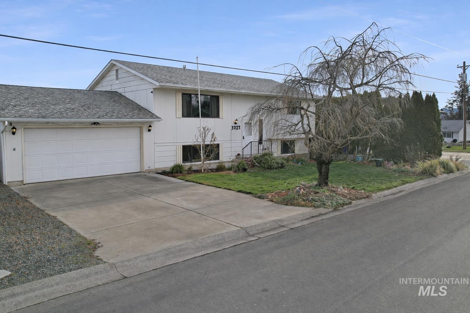 3727 17th Street Lewiston, ID 83501 - Photo 2 of 10 Bi-level home featuring a front lawn, concrete driveway, an attached garage, and a shingled roof
