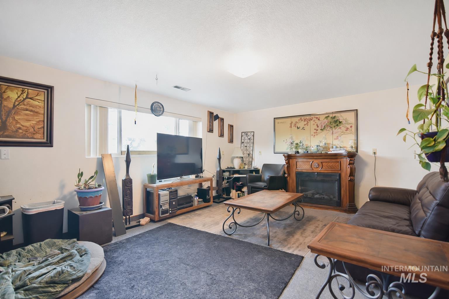 3727 17th Street Lewiston, ID 83501 - Photo 5 of 10 Living area featuring a glass covered fireplace and carpet flooring