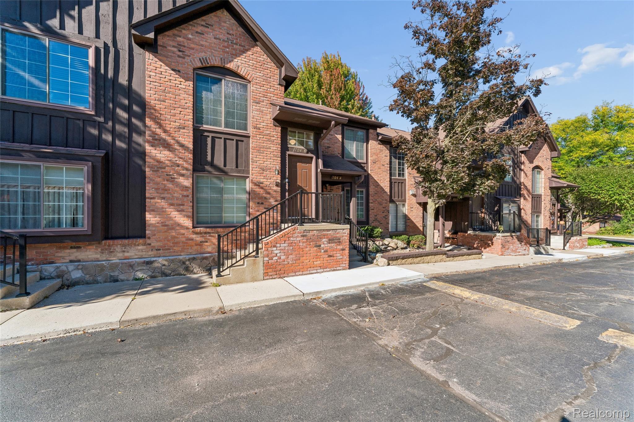 704 South Brady Road, Unit B Dearborn, MI 48124 - Photo 2 of 16 Multi-level brick exterior with wood-paneled accents, arched window details, and black metal railings