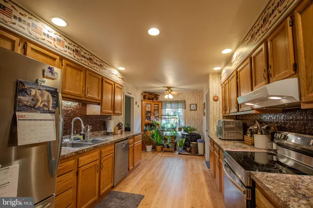 a kitchen with stainless steel appliances granite countertop sink stove and cabinets