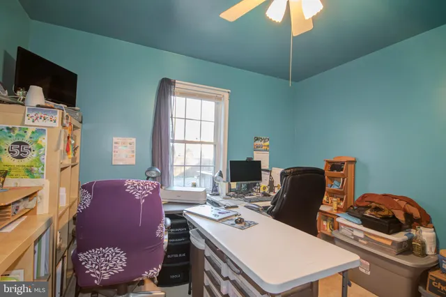 a view of a workspace with furniture and a window