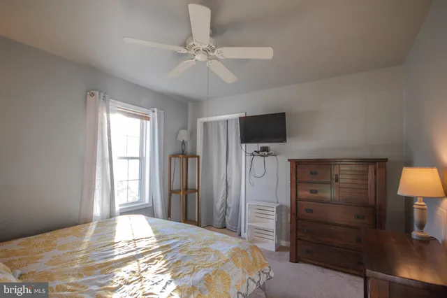 a bedroom with a bed and a flat tv screen on a dresser
