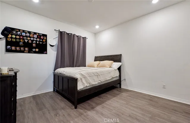 a bedroom with a bed window and wooden floor