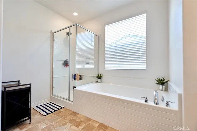 a spacious bathroom with a tub sink and mirror