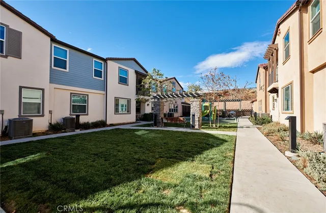 a backyard of a house with barbeque oven table and chairs
