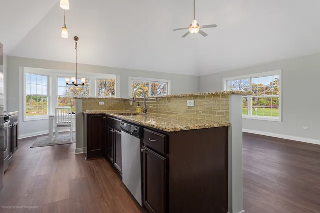 a kitchen with granite countertop a stove a sink and a refrigerator