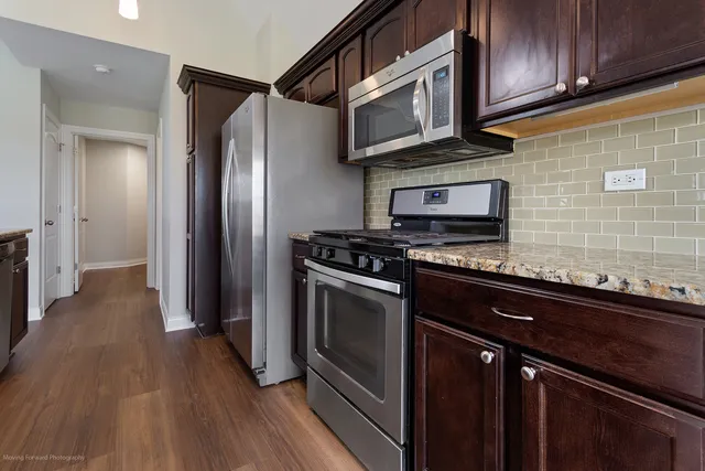 a kitchen with stainless steel appliances granite countertop a stove microwave and refrigerator