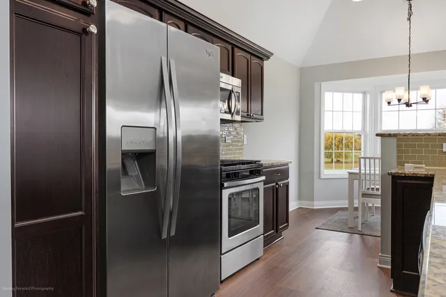 a kitchen with stainless steel appliances granite countertop a refrigerator and a stove