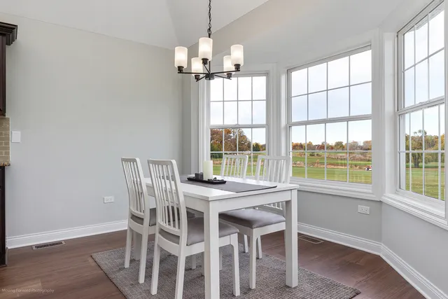 a view of a dining room with furniture a chandelier and wooden floor
