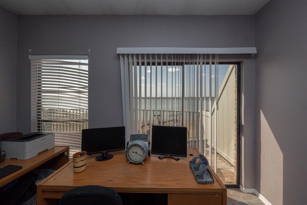 1418 Signal Ridge Place Rockwall, TX 75032 - Photo 6 of 35 Sliding glass patio door with vertical blinds, private balcony, and wood-finish desk