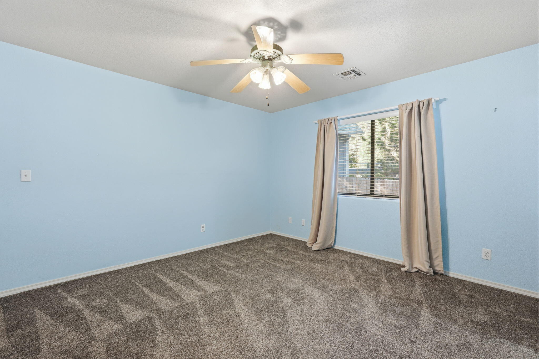 310 North Trailwood Road Payson, AZ 85541 - Photo 23 of 55 an empty room with a chandelier fan and windows