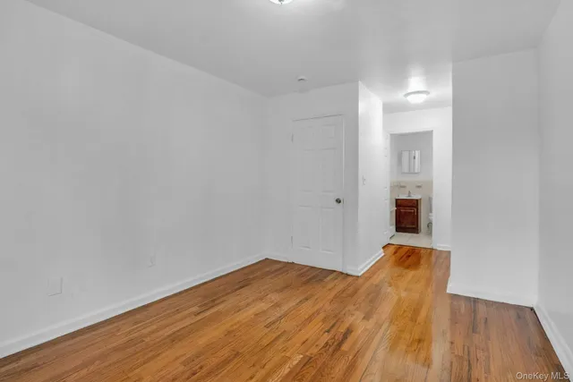 a view of a room with wooden floor and a ceiling fan