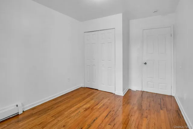 a view of a room with wooden floor and white walls