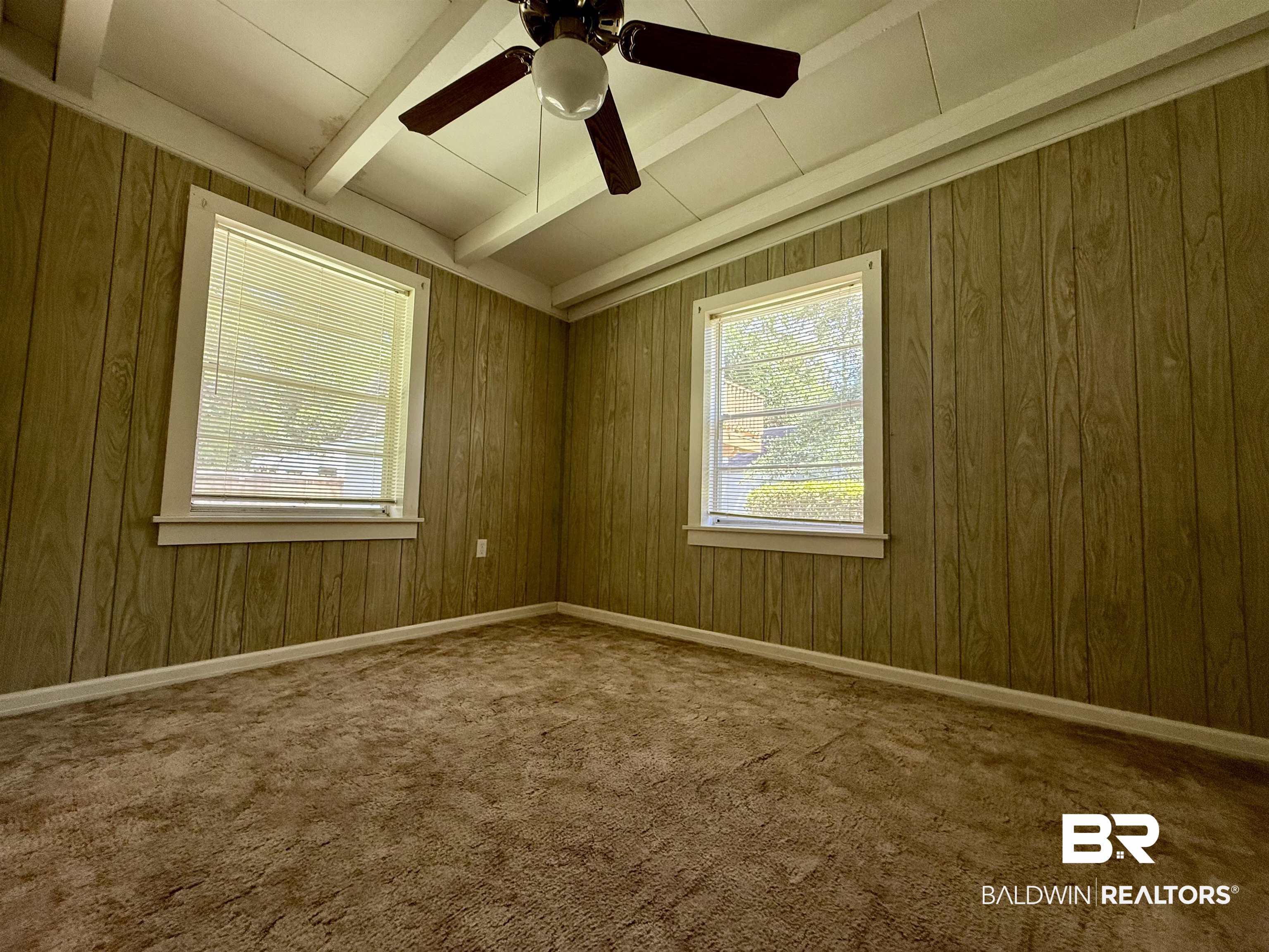 103 Kimberly Street Brewton, AL 36426 - Photo 10 of 18 Empty room featuring beam ceiling, ceiling fan, carpet, and wooden walls
