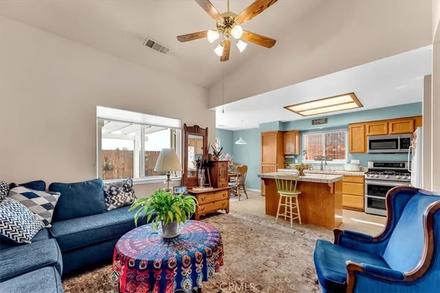 a living room with furniture kitchen view and a large window