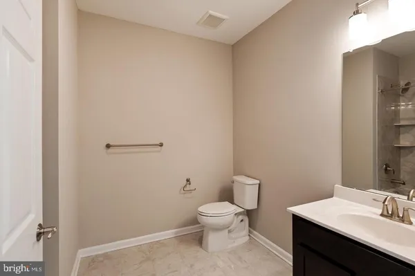 a bathroom with a toilet a sink and mirror