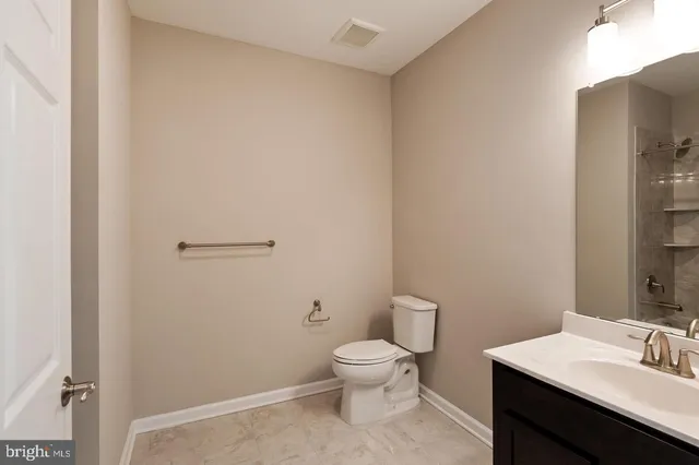 a bathroom with a toilet a sink and mirror