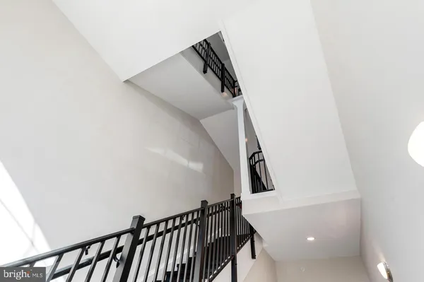 a view of staircase with railing and white walls
