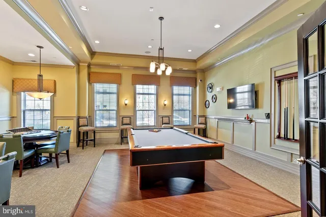 a living room with furniture a fireplace and large windows