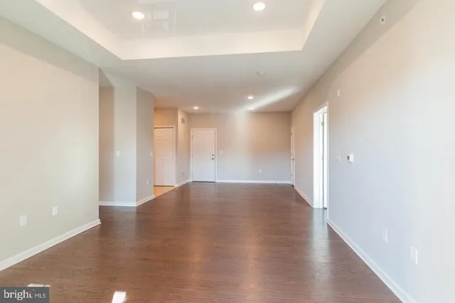 a view of an empty room with wooden floor
