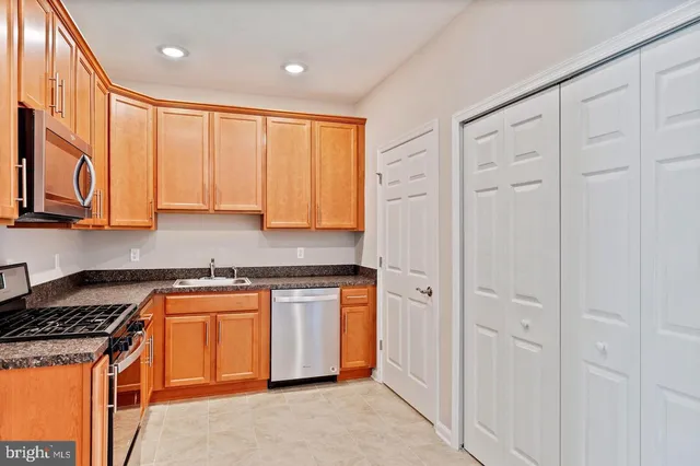 a kitchen with stainless steel appliances granite countertop a stove a sink and a refrigerator