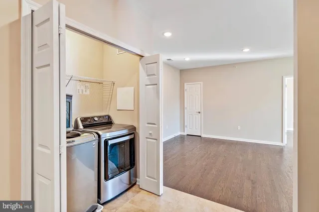 a view of kitchen with stainless steel appliances wooden floor and a window
