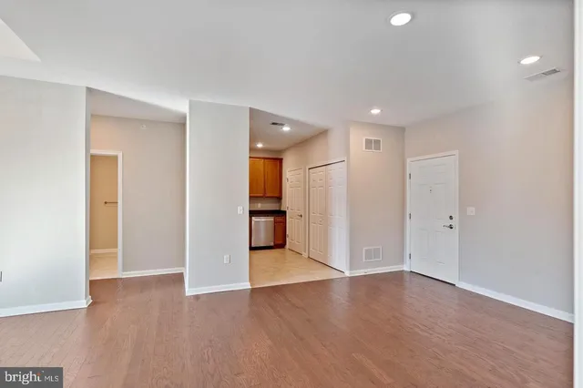 a view of an empty room with wooden floor