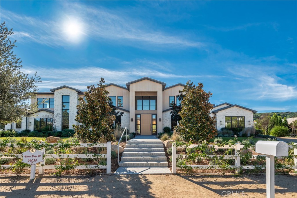 24050 Hidden Ridge Road Hidden Hills, CA 91302 - Photo 2 of 45 a front view of a house with garden