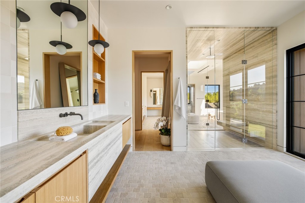 24050 Hidden Ridge Road Hidden Hills, CA 91302 - Photo 24 of 45 a spacious bathroom with a granite countertop tub sink and mirror