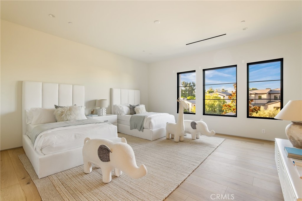 24050 Hidden Ridge Road Hidden Hills, CA 91302 - Photo 25 of 45 a spacious bedroom with a large bed and a large window