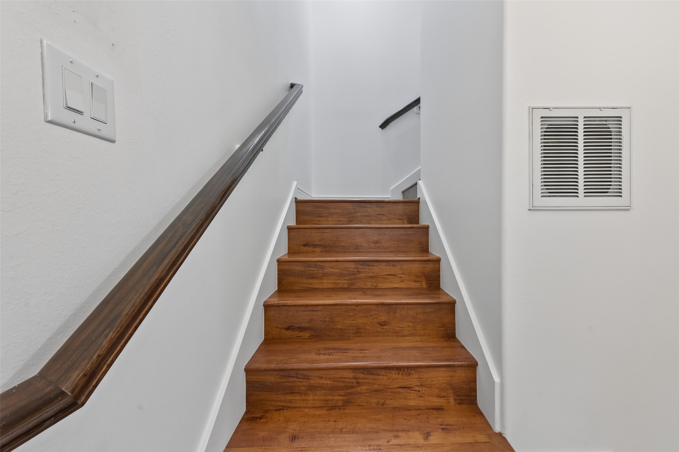620 Rutland Street, Unit A Houston, TX 77007 - Photo 12 of 46 This photo shows a staircase with wooden steps and white walls.