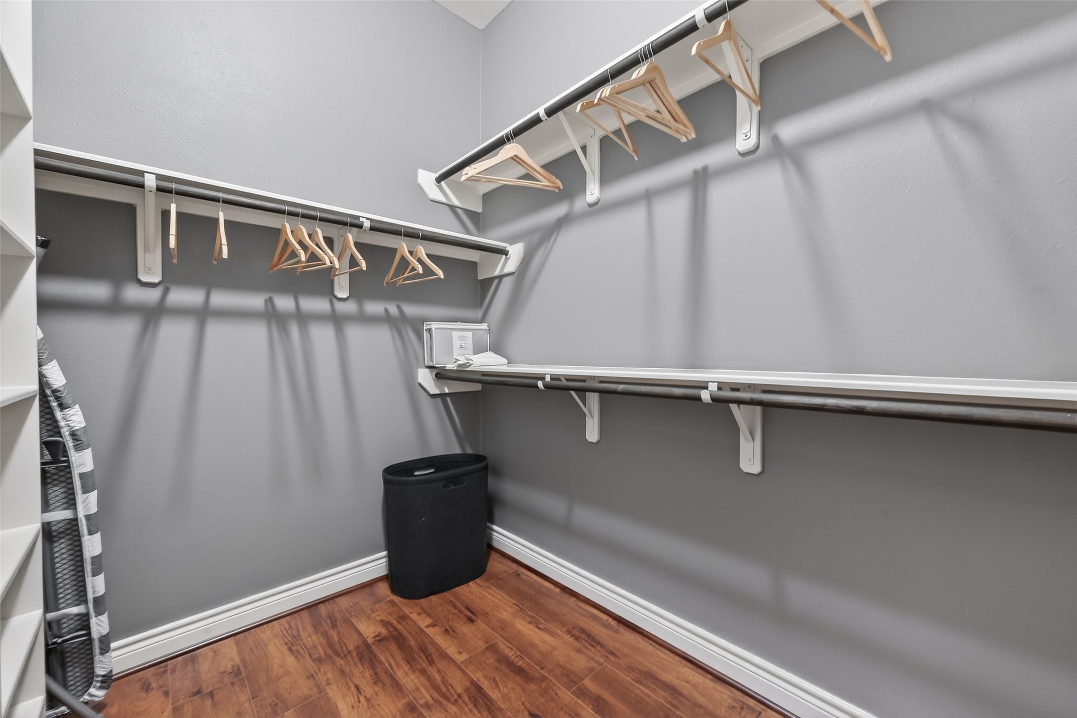 620 Rutland Street, Unit A Houston, TX 77007 - Photo 27 of 46 This spacious walk-in closet features sleek gray walls, hardwood floors, and ample shelving and hanging space, perfect for organizing clothing and accessories.