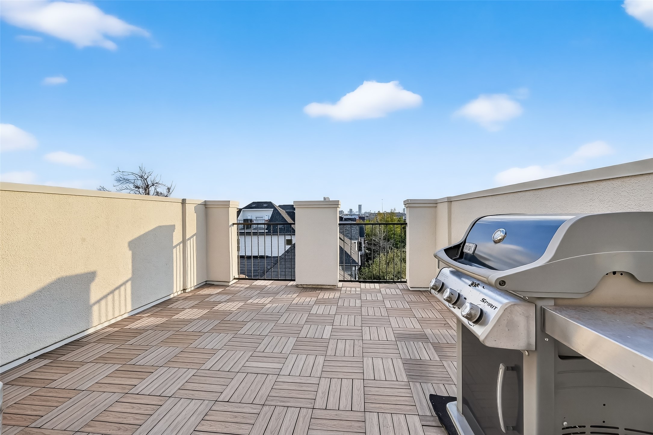 620 Rutland Street, Unit A Houston, TX 77007 - Photo 28 of 46 Spacious rooftop terrace with stylish wood-patterned flooring, equipped with a modern grill, perfect for outdoor entertaining and offering a clear view of the surrounding area.