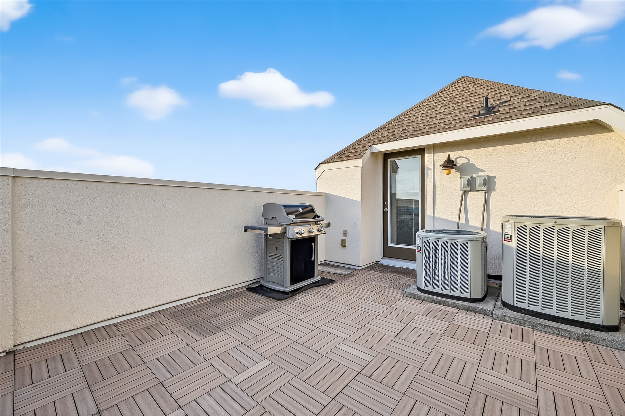 620 Rutland Street, Unit A Houston, TX 77007 - Photo 29 of 46 This photo showcases a spacious rooftop terrace with tile flooring, equipped with a grill and two HVAC units. It's ideal for outdoor entertaining and enjoying the open sky.