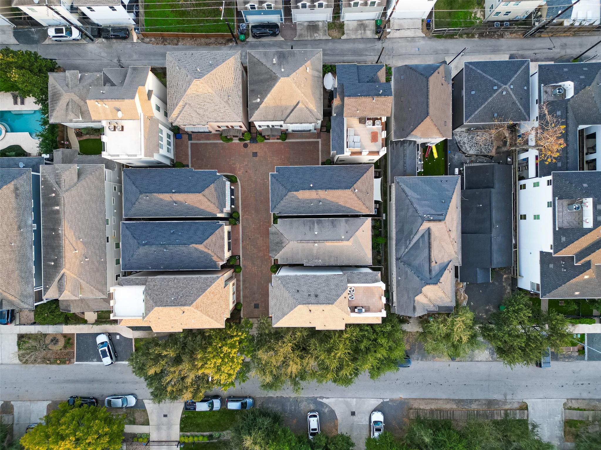 620 Rutland Street, Unit A Houston, TX 77007 - Photo 40 of 46 This aerial photo showcases a neatly arranged residential area with closely packed houses and a central courtyard. The neighborhood features well-maintained homes, a communal driveway, and surrounding greenery, offering a cozy and organized living environment.
